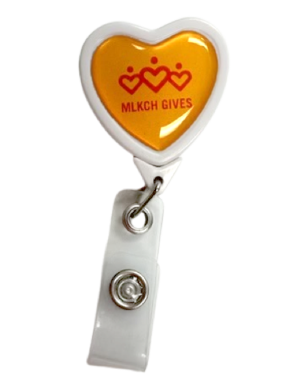 Heart shaped badge with orange text that reads "MLKCH Gives"