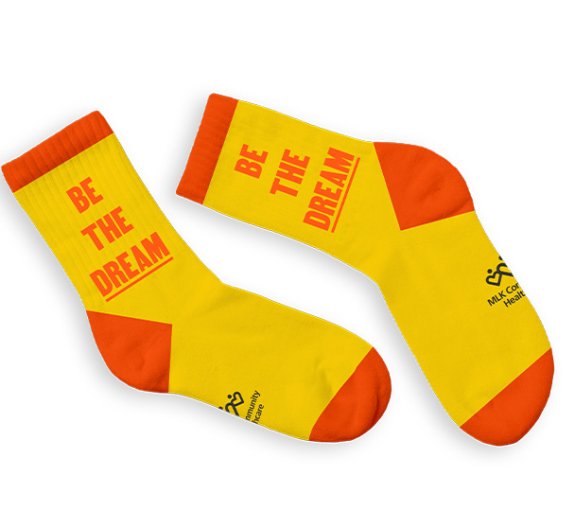 Orange text that reads "Be the Dream" on yellow socks