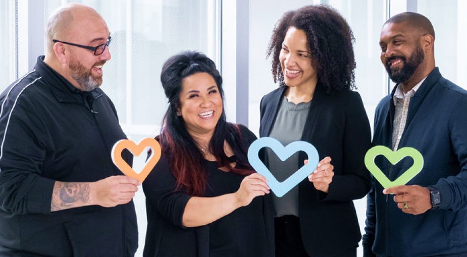 Four staff members holding paper hearts